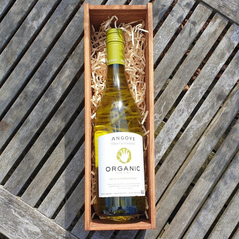 Bottle of Angove Organic white wine in a wooden box on a wooden surface
