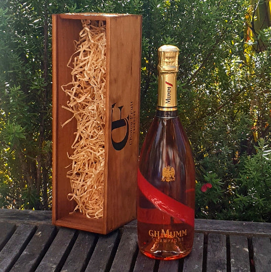 Bottle of G.H. Mumm champagne with wooden gift box outdoors