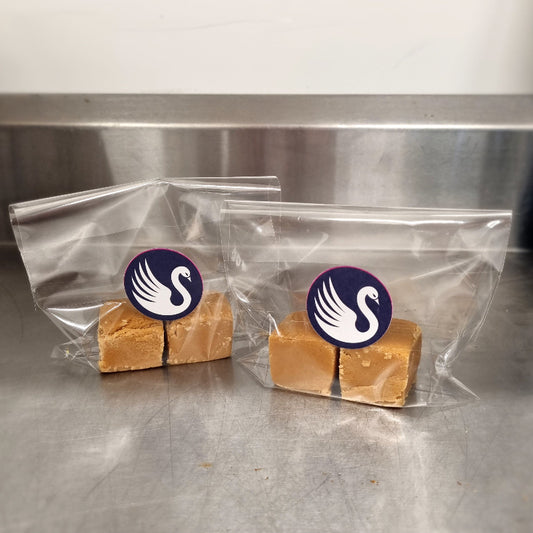 Two pieces of fudge in clear bags with a logo on a metallic surface