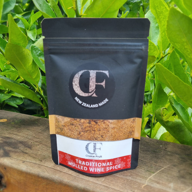 Packaged mulled wine spice with 'CF' branding on a wooden surface with green leaves in the background
