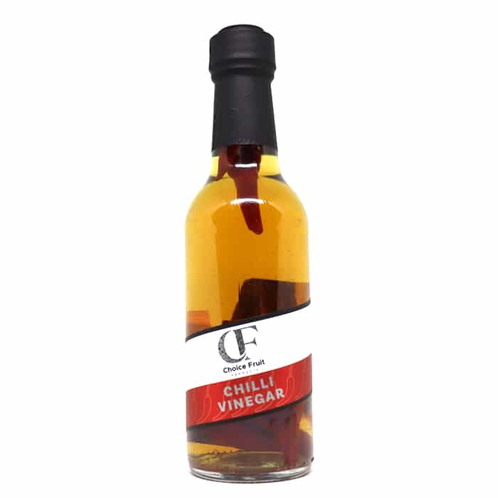A bottle of infused chili vinegar with a label that reads 'Chilli Vinegar'. The vinegar appears to be clear with red chili flakes visible throughout.