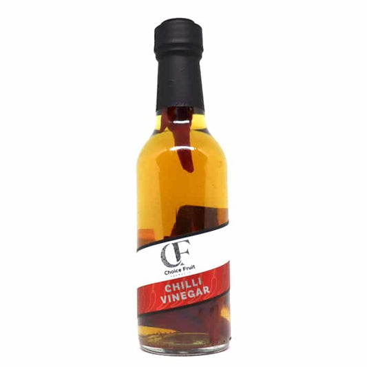 A bottle of infused chili vinegar with a label that reads 'Chilli Vinegar'. The vinegar appears to be clear with red chili flakes visible throughout.