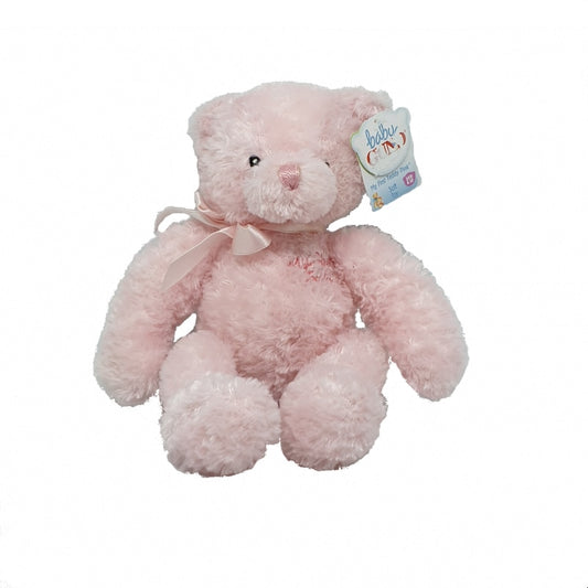 A pink plush teddy bear with a satin ribbon bow around its neck, tagged with a 'Gund' brand tag.