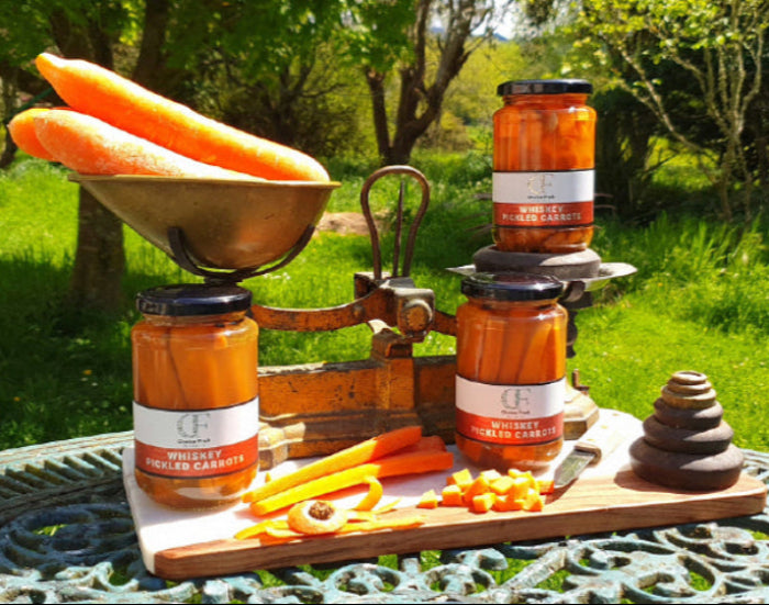 Jars of whiskey carrots on a wooden scale with carrots outdoors